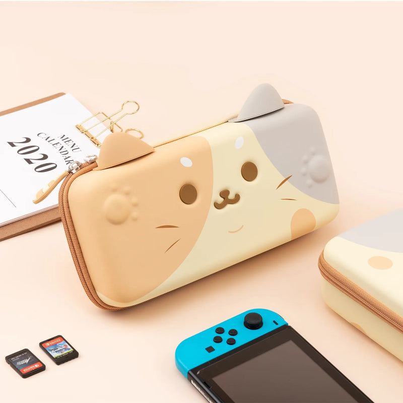 Cute cat-shaped carrying case for Nintendo Switch device on a light surface with a 2020 calendar.