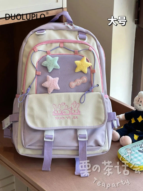 Kawaii backpack with star designs on a wooden surface.