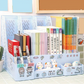 Desk organizer with books, stationery, and decorative items on a desk.