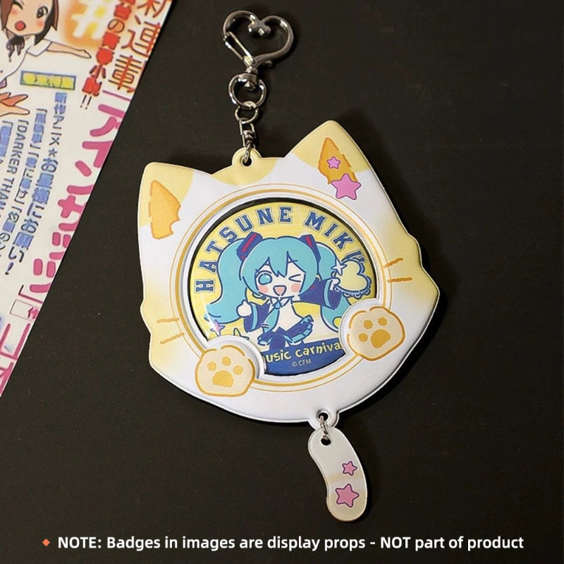 A Hatsune Miku acrylic keychain shaped like a cat head, featuring a white and pale yellow cat-face outline with printed character artwork and paw prints, attached to a silver clasp. A small matching charm hangs below.
