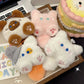 Set of cute plush keychains on a desk with a laptop and stationery items.