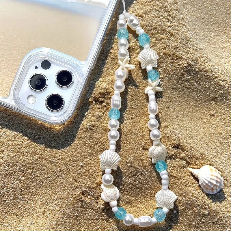 Mermaid treasure phone charm bracelet displayed on sandy beach