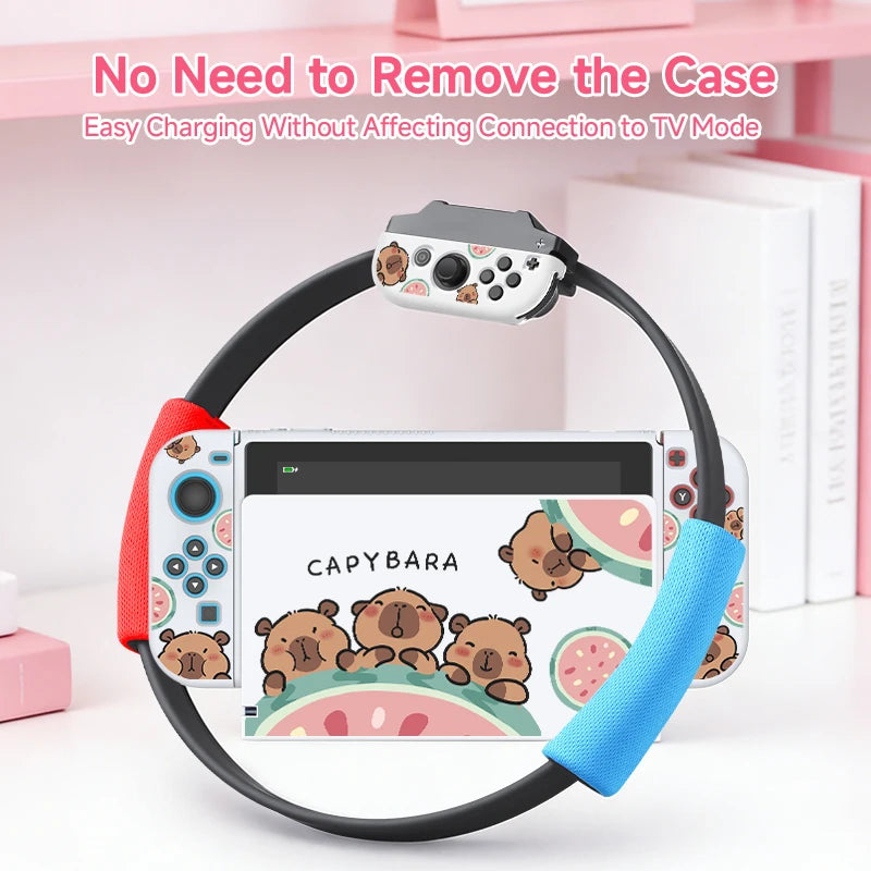 kawaii capybara watermelon switch case, this is the white version with three capybaras holding onto a watermelon while displaying different happy expressions on their faces, this is shown on a white desk being docked to demonstrate it can charge with  the case on