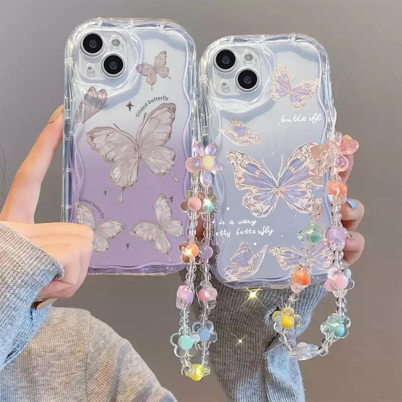 Kawaii phone cases with butterfly design one design has subtle hints of purple along side the butterfly while the other design has glitter round the outline of the butterfly and a colorful lanyard held by a person