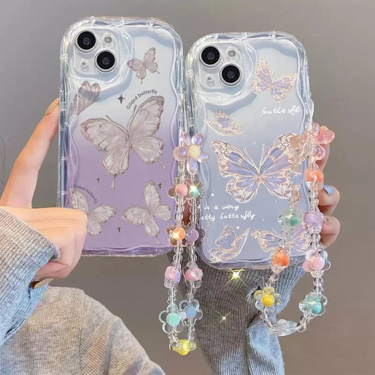 Kawaii phone cases with butterfly design one design has subtle hints of purple along side the butterfly while the other design has glitter round the outline of the butterfly and a colorful lanyard held by a person
