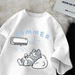 White t shirt with a cartoon design of a cat relaxing under an air conditioner, labeled 'Summer', on a textured surface.