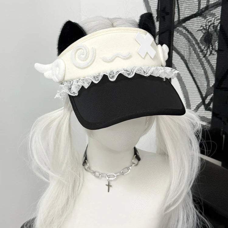 Mannequin head with a black cap featuring white decorative elements, white wig, and silver necklace.