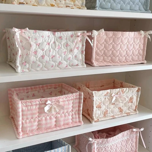 Set of pink and white patterned storage baskets on a shelf.