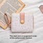 Small pink wallet with cat pattern on a white surface with an open book
