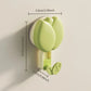 Green wall hook with measurements on a beige background