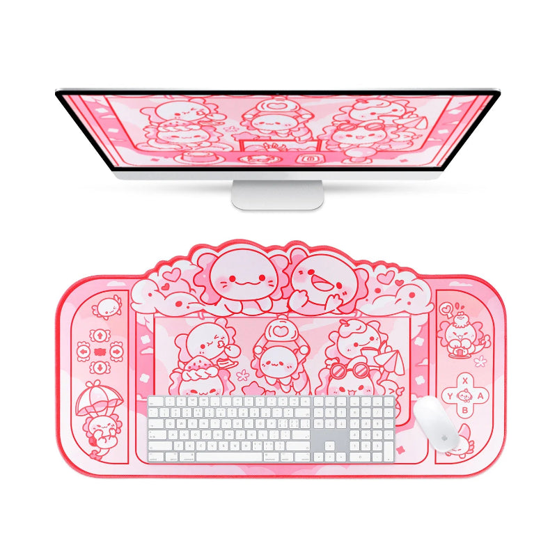 Pink desk setup with cartoon axolotl characters on a monitor, keyboard, mouse, and mouse pad.