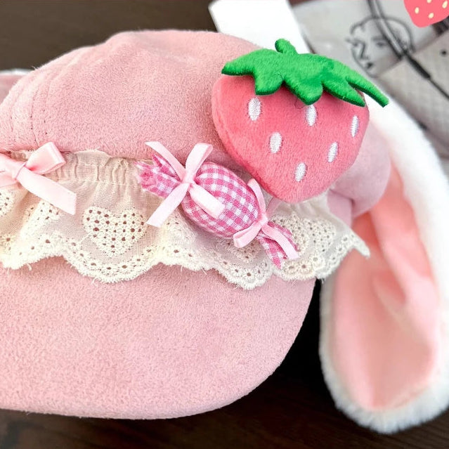 Kawaii pink bunny hat with plush strawberry accent and lace.