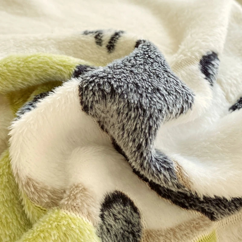 Close-up of a soft, multi colored blanket with a fuzzy texture , the image of a panda on a blanket.