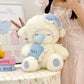 White lamb plushie toy with blue accents held by a person in a light pink room.