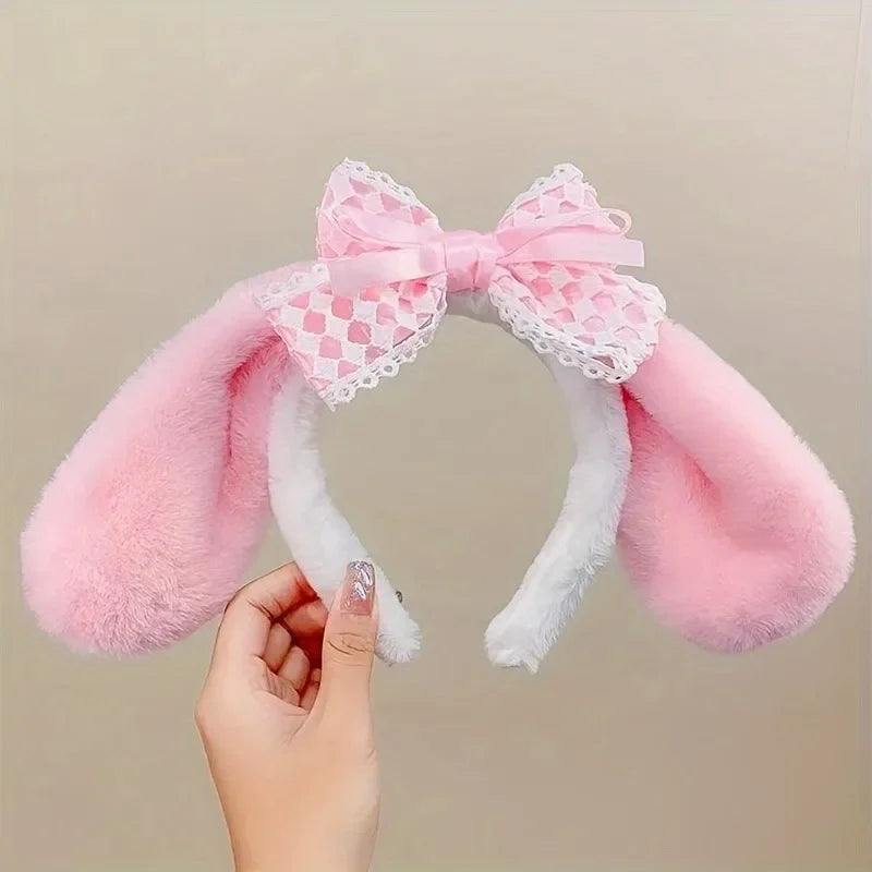 Kawaii Bunny Ears Headbands, this design is the pink and white headband being held up against a white wallpaper.