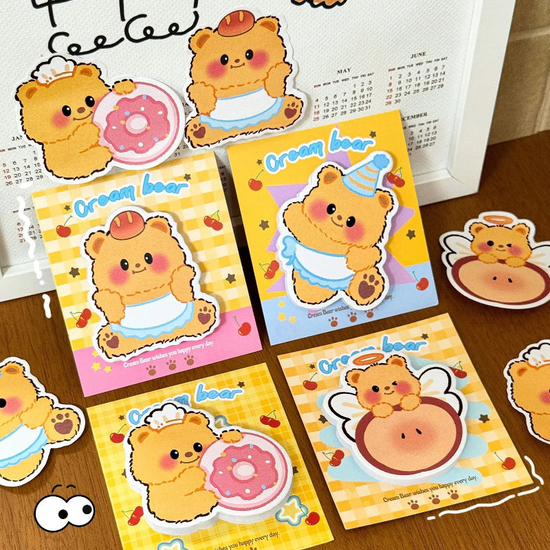 This image is displaying the 4pcs Creamy Bear Sticky Notes 4 different kawaii designs that come in the pack, this is shown on a wooden desk.