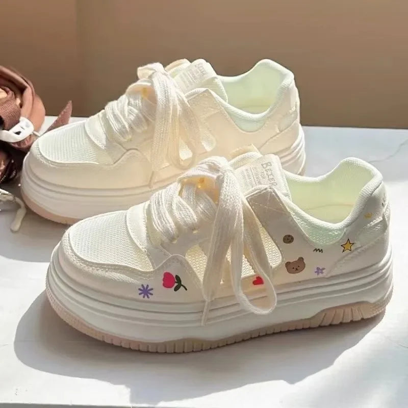 Kawaii white sneakers with floral and bear design on a white surface.
