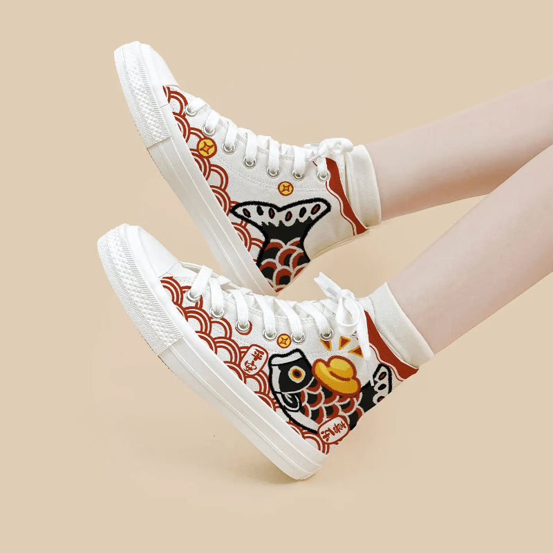 A pair of white high-top canvas sneakers with Japanese-inspired koi fish and wave patterns, shown on a model's feet against a solid beige background.