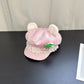 Pink kawaii hat with bear ears on a dark surface