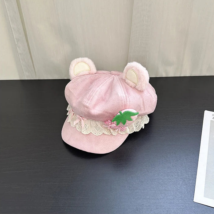 Pink kawaii hat with bear ears on a dark surface