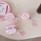 Pink swiss roll shaped air pod case on a white table.