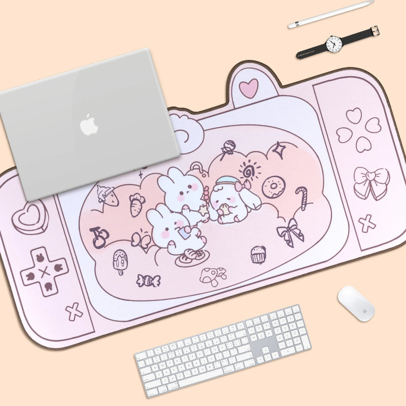 Pink kawaii-themed mouse pad with a laptop, keyboard, and mouse on a beige surface