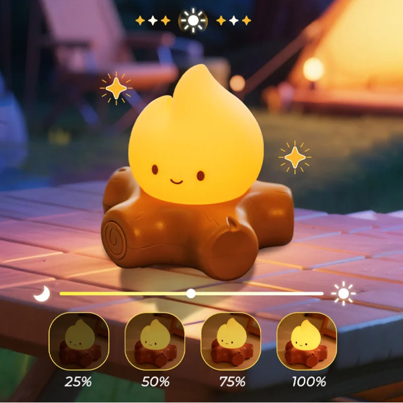 Cute campfire shaped nightlight with stepless dimming feature on a wooden surface with a blurred outdoor background.