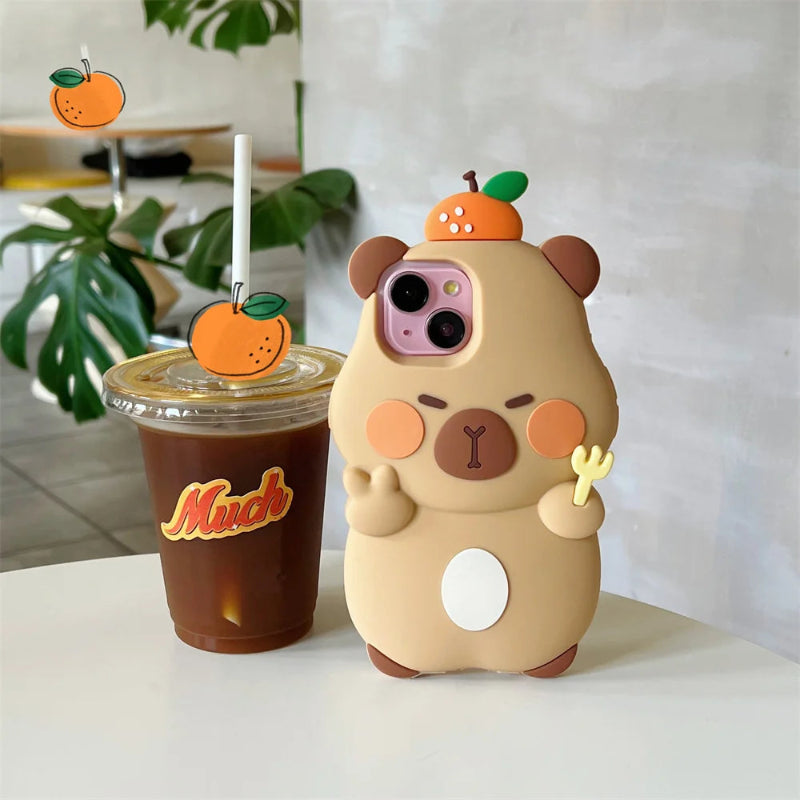 Kawaii Capybara phone case with cartoon design next to a coffee cup with an orange on top