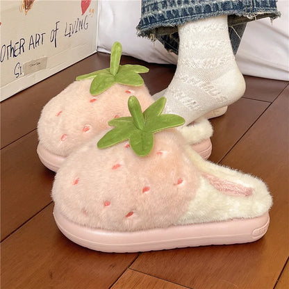 Pink strawberry slippers worn indoors on a wooden floor.