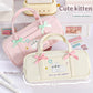 Two pencil cases with cute kitten designs and embroidered text on a light background.