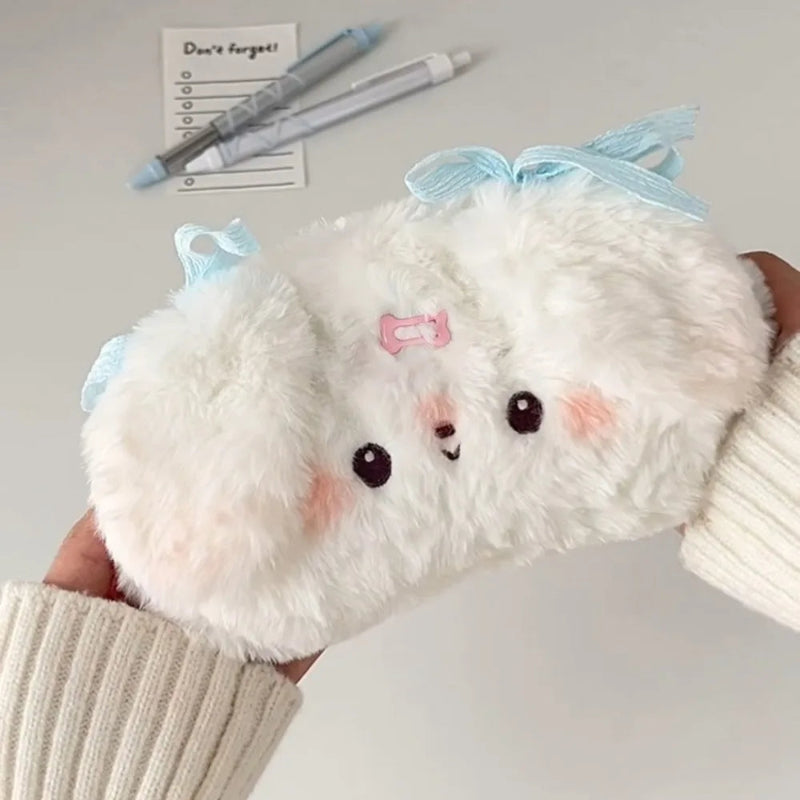 Plush white puppy pencil case  with a blue bow held by a person.