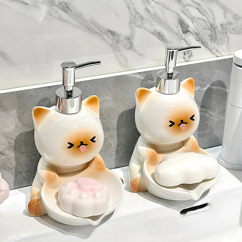 Two cat-shaped soap dispensers on a marble countertop.