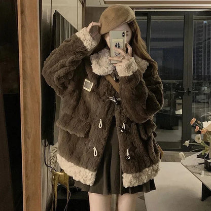 A person takes a mirror selfie wearing a dark brown faux fur jacket with beige sherpa lining on the collar, cuffs, and hem, paired with a matching beige beret and dark brown pleated skirt.