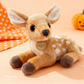 Plush deer toy with a pumpkin and polka dot fabric in the background