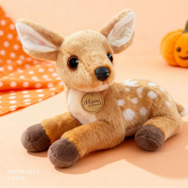 Plush deer toy with a pumpkin and polka dot fabric in the background