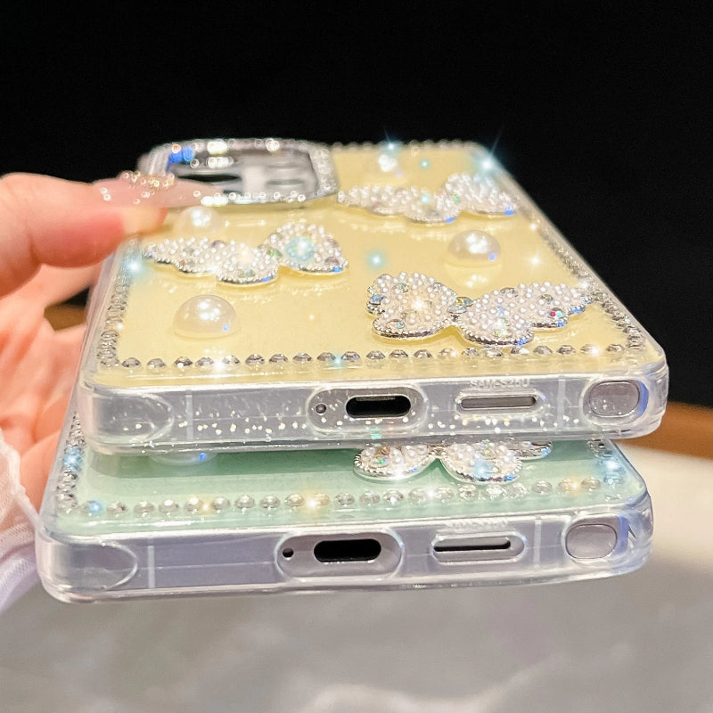 Phone case with decorative elements held by a hand , one case is a mint green color the other is a pastel yellow