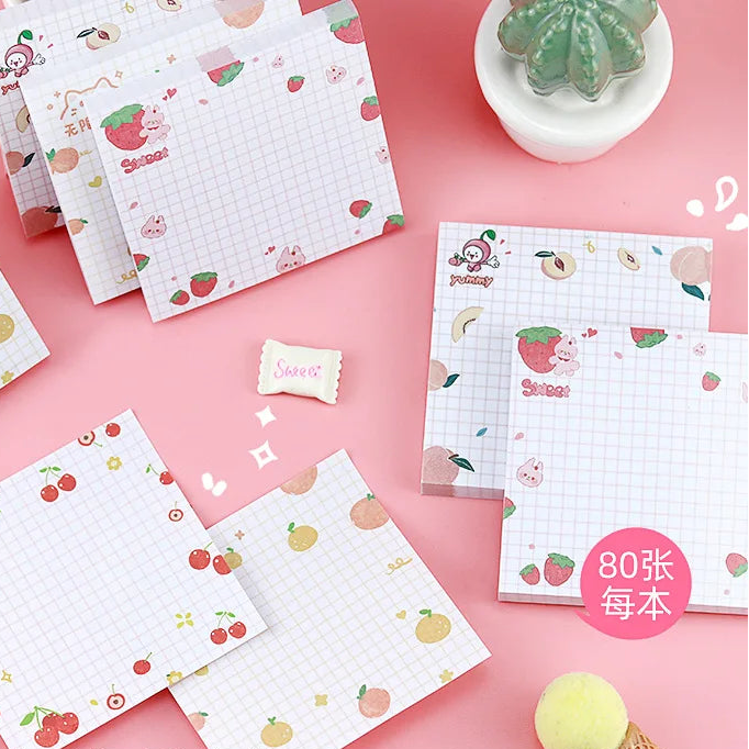 Note pads with fruit designs on a pink background