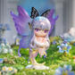 Fairy figurine with purple wings sitting on a grassy area with flowers