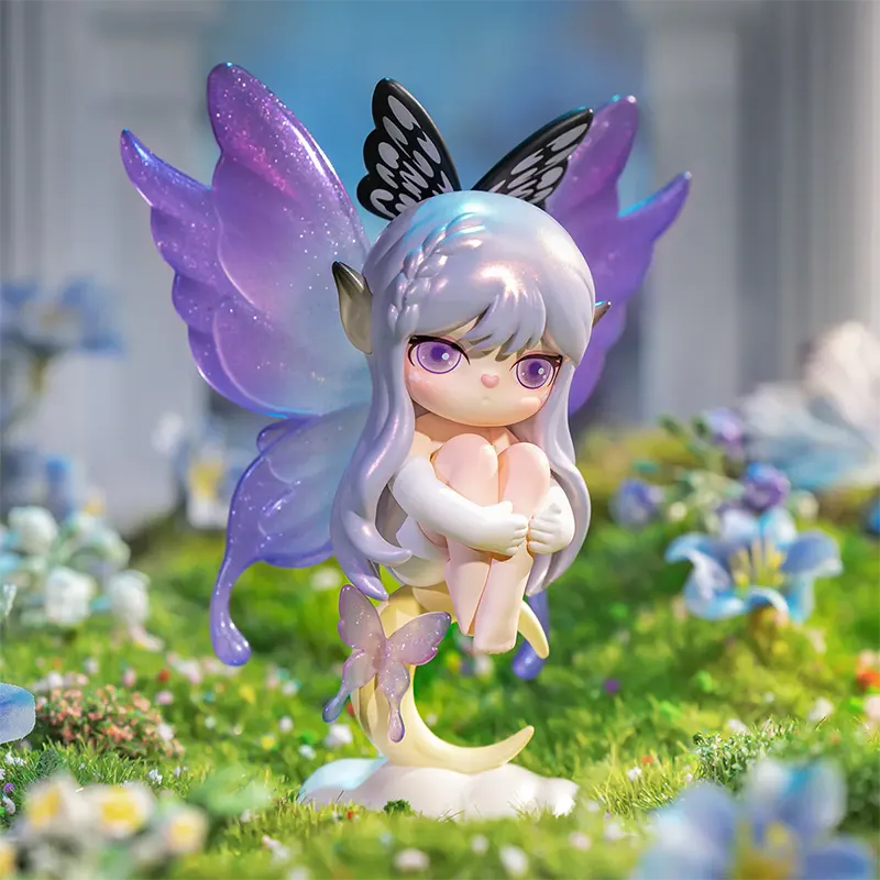 Fairy figurine with purple wings sitting on a grassy area with flowers