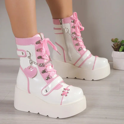 White and pink platform boots with decorative elements on a neutral background