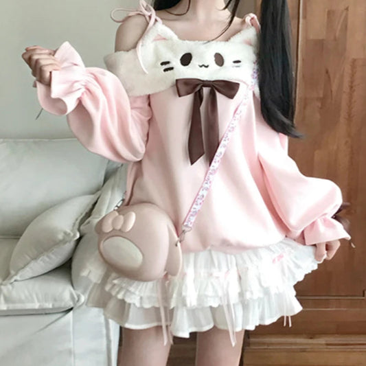 Person wearing a pink and white shirt with cat ears and face in a room.