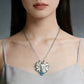 Woman wearing a silver Kitsune necklace with a detailed pendant against a neutral background