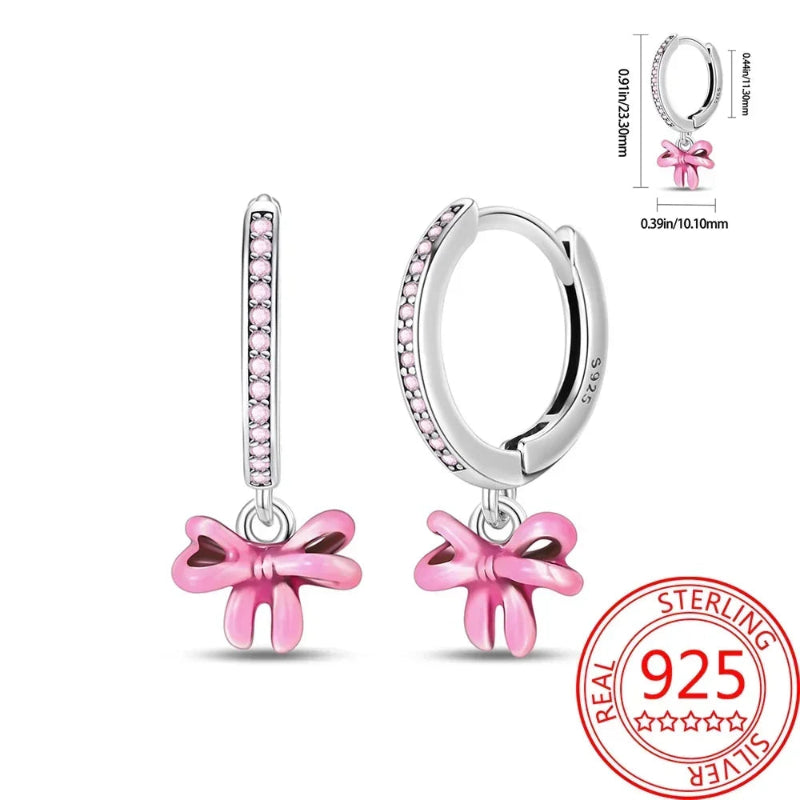 Pair of pink bow earrings with sterling silver stamp on a white background