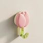 Pink and green tulip-shaped wall hook on a beige background