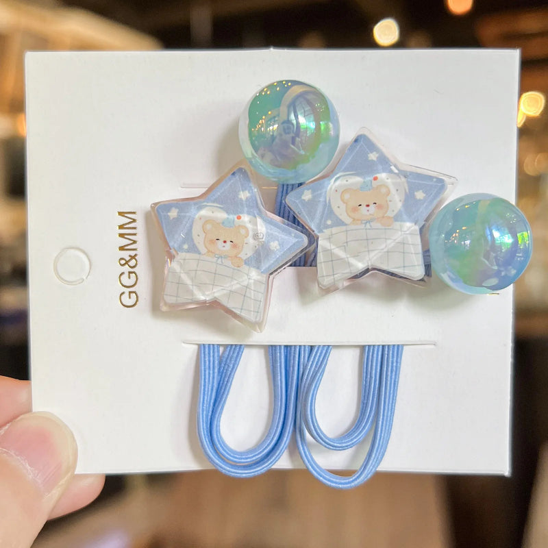 Star-shaped hair clips with teddy bear design on a white card, held by a hand.