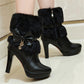 Black high-heeled boots with fluffy tops and a bow detail on a light background