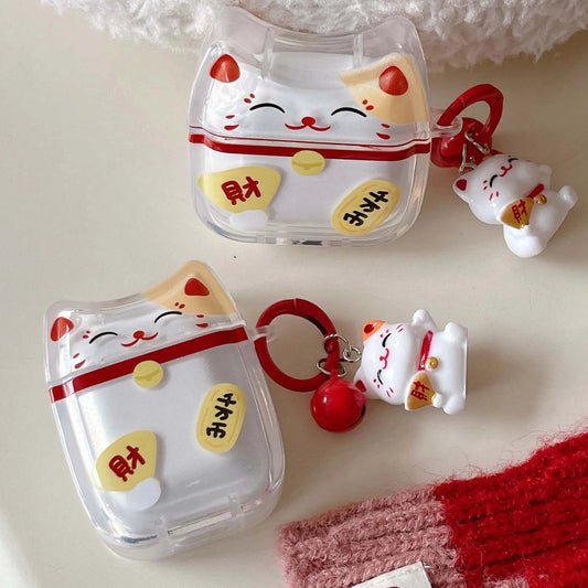 Set of lucky cat-themed airpods including a clear case, keychain, and figurine on a light background.