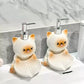 Two kawaii cat-shaped soap dispensers on a bathroom counter with a marble wall background.