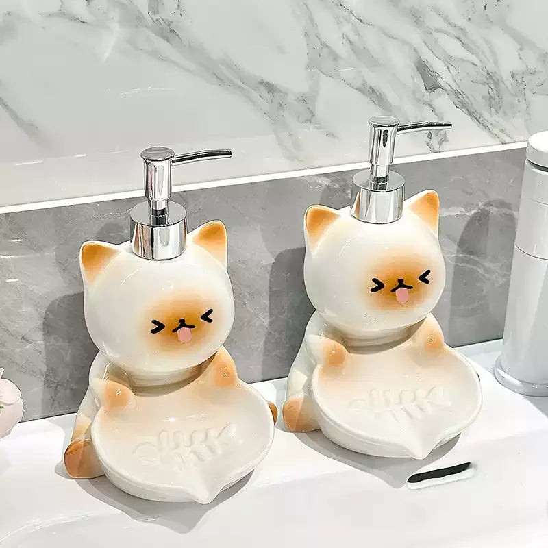 Two kawaii cat-shaped soap dispensers on a bathroom counter with a marble wall background.