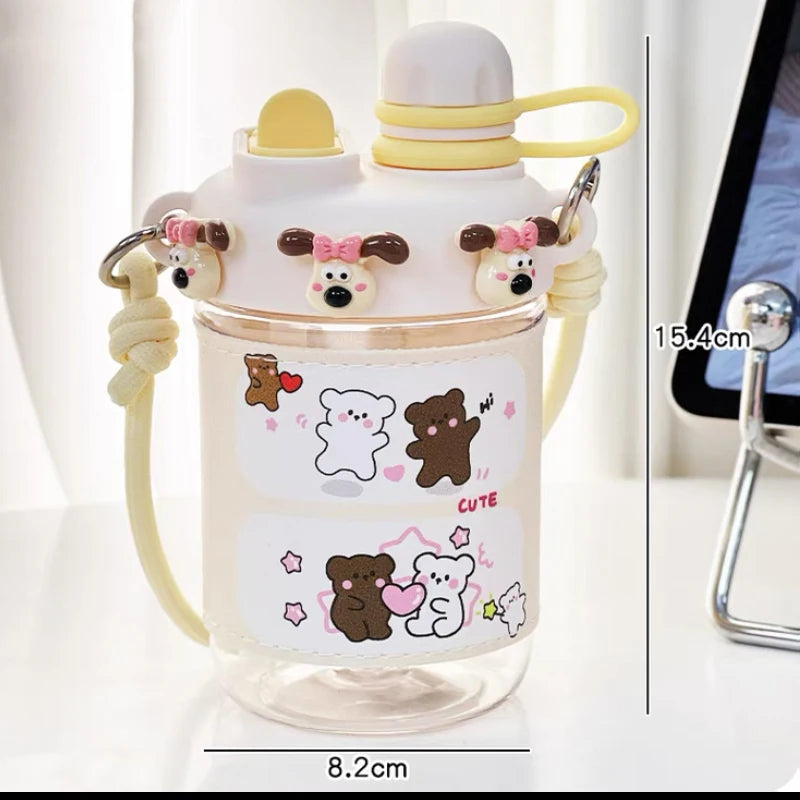  cute water bottle with cartoon designs held by hands against a blurred background. displaying the measurements of it.